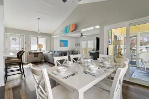 a dining room and living room with a white table and chairs at Heron Hideaway Canal-Front 3-Bedroom Home in Ocean Pines, MD, Near Ocean City Beaches in Berlin