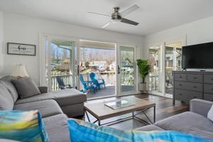 a living room with a couch and a tv and a table at Heron Hideaway Canal-Front 3-Bedroom Home in Ocean Pines, MD, Near Ocean City Beaches in Berlin