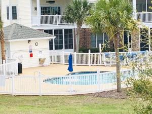 a white fence around a swimming pool in a house at Calming & Relaxing condo in the center of MB in Myrtle Beach