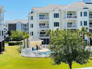 a large apartment building with a pool in a yard at Calming & Relaxing condo in the center of MB in Myrtle Beach