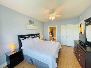 a bedroom with a bed and a ceiling fan at Calming & Relaxing condo in the center of MB in Myrtle Beach