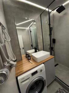 a bathroom with a washing machine and a mirror at Стильная однокомнатная квартира in Almaty