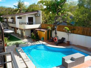 a house with a swimming pool in front of a house at Elmarie Beach Resort in San Fabian