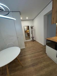 a dining room with a white table and a table at Стильная однокомнатная квартира in Almaty