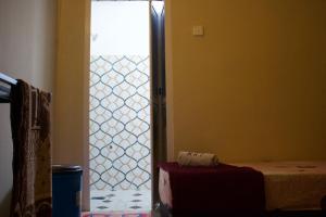 a bedroom with a door open to a room with a bed at Chatek Family Inn in Kampong Pasir Hantu