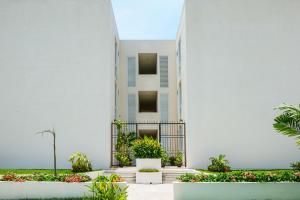 a white building with plants in front of it at Departamento amplio con alberca y asador - Hasta 14 personas - B3 in Puerto Vallarta