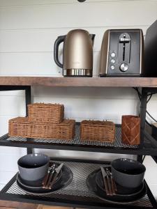 a kitchen shelf with utensils and a tea kettle at Jacaranda Cottage 5 min by Train or 7 min drive to Parramatta City in Wentworthville
