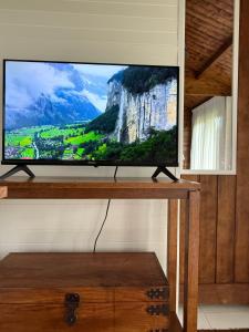 a flat screen tv sitting on top of a table at Jacaranda Cottage 5 min by Train or 7 min drive to Parramatta City in Wentworthville +11 photos