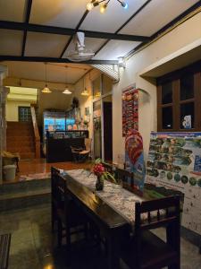 a dining room with a table and chairs and a counter at Saphaothong guesthouse in Vang Vieng