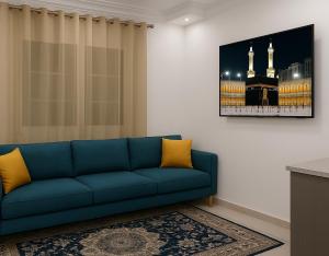 a blue couch in a living room with a picture of a mosque at Dar El Yasamine in Houmt Souk