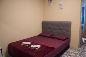 a small bedroom with a bed with two towels on it at Chatek Family Inn in Kampong Pasir Hantu