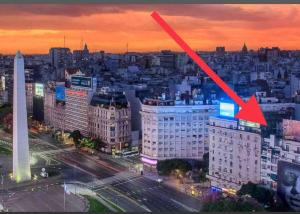 a view of a city at night with a red arrow at corazón obelisco 2 in Buenos Aires