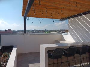 a balcony with a table and chairs on a roof at Departamento en Chihuahua in Chihuahua