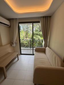 Una sala de estar con un sofá y una ventana grande. en 1 bedroom in Kamala Beach, en Kamala Beach 5 fotos más