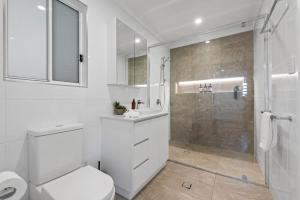 ブリスベンにあるStylish 1BR Apt in Quiet & Leafy Paddington Streetの白いバスルーム(トイレ、シャワー付)