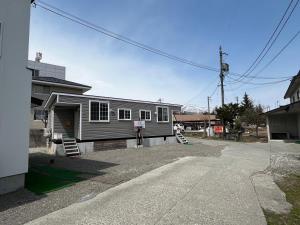 a gray house with a driveway in front of it at 赤だすき_別邸 in Hakuba