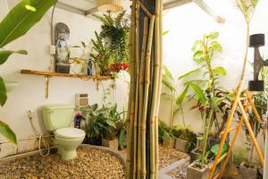 a bathroom with a toilet and a bunch of plants at PBrooms in Mui Ne +56 photos