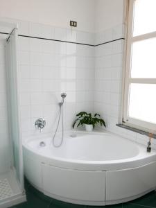 a white bath tub with a plant in a bathroom at Guesthouse Flora in Lodi