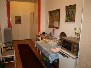 eine Küche mit einem Tisch und einem TV in der Unterkunft Pension Gross in Wien