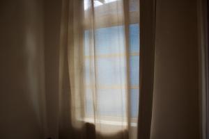 a window with a curtain in a room at Chatek Family Inn in Kampong Pasir Hantu