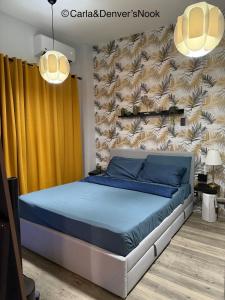 a bedroom with a bed with blue sheets and a wall at A perfect beach getaway in San Juan in San Juan