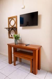 a wooden table with a tv on a wall at Hotel Palmazul - Viña del Mar in Omoa