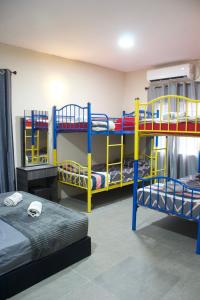 a room with several bunk beds in a room at Chatek Family Inn in Kampong Pasir Hantu