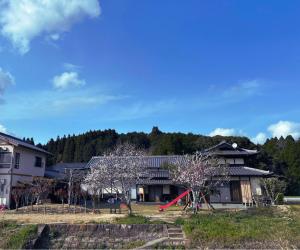 una casa con parco giochi e scivolo rosso di 農家民宿うめむら1組様限定 a Imari