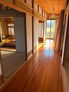 una stanza con pavimenti in legno e un grande specchio di 農家民宿うめむら1組様限定 a Imari