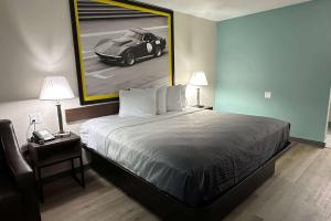 una camera con un letto e una foto di un'auto di Super 8 by Wyndham Kannapolis a Kannapolis