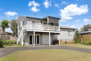 a white house with a balcony and a yard at Good Vibes at Surf Beach with Spa in Surf Beach