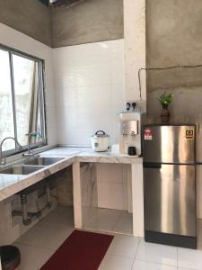 a kitchen with a stainless steel refrigerator and a sink at Zahara Homestay in Sandakan