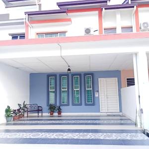 a house with a blue front door with a bench at Zahara Homestay in Sandakan