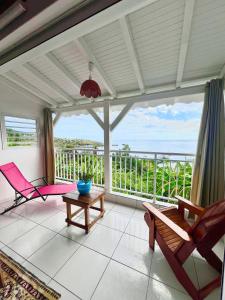 a living room with a view of the ocean at Anara-Rose ensoleillée in Bouillante