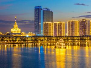 une ligne d'horizon de la ville avec un voilier dans l'eau la nuit dans l'établissement Cozy Apartment - Masteri WF Vinhomes Ocean Park, à Gia Lâm Pho