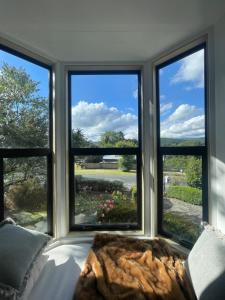 a room with three windows with a couch in front at Islay House - stylish villa in historic Lawrence in Lawrence