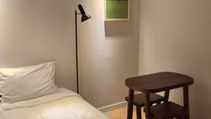 a small stool next to a bed with a table at Stay A Hotel Gwangan in Busan