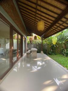 un patio esterno con un tavolo e un soffitto di ASTAGINA VILLA ad Ubud