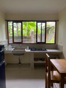 una cucina con un grande lavandino e una finestra di ASTAGINA VILLA ad Ubud