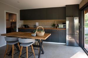 una cucina con armadi blu e un tavolo in legno con sedie di Eco Friendly Cottage at Simple Patch Farm Wingham a Wingham
