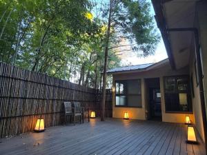 a house with a wooden deck with lights on it at 阿部倉温泉 Abekura Onsen in Yokosuka