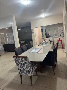 a dining table and chairs in a living room at Casa Ramos in Itanhaém