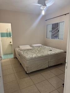 a bedroom with a bed in a room with a window at Casa Ramos in Itanhaém +12 photos