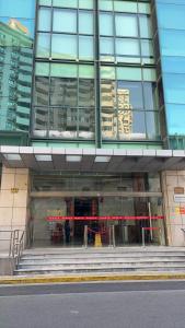 duży szklany budynek z czerwoną wstążką z przodu w obiekcie Tech-X Jing'an Hotel w Szanghaju