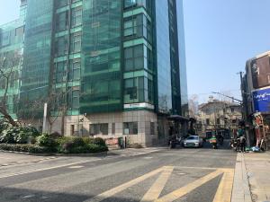 pusta ulica przed wysokim szklanym budynkiem w obiekcie Tech-X Jing'an Hotel w Szanghaju