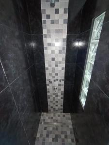 a shower with a tiled floor and two windows at The Herman House in Cerrillos