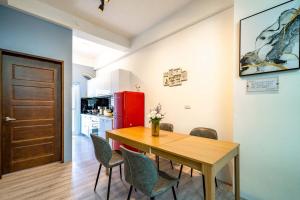 Una cocina y un comedor con mesa y sillas de madera. en Senhuojia Homestay, en Toucheng