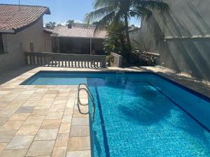a swimming pool with blue water in a yard at Casa Ramos in Itanhaém
