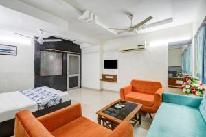 a hotel room with a bed and a couch and chairs at Hotel Royal Stay, Pakwan Sg Highway in Ahmedabad