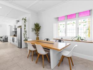 a kitchen and dining room with a wooden table and chairs at Beautiful villa in Napier with spa in Napier